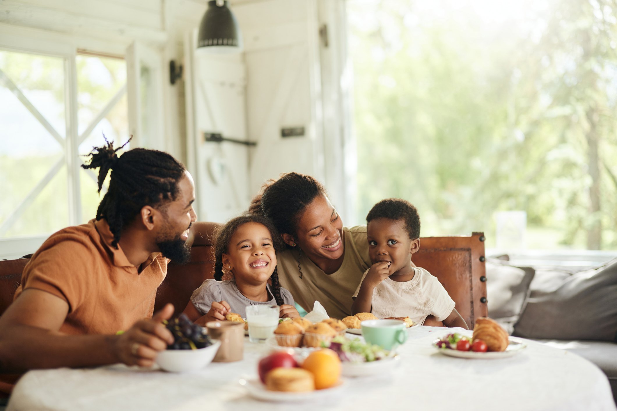 A happy family of four enjoying breakfast together in a bright, cozy home