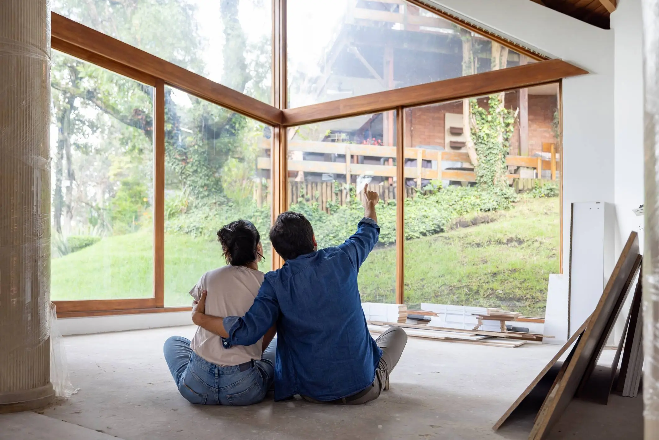 Couple sitting on the floor of an unfinished room, discussing the potential of using a HELoan for home improvements or renovations