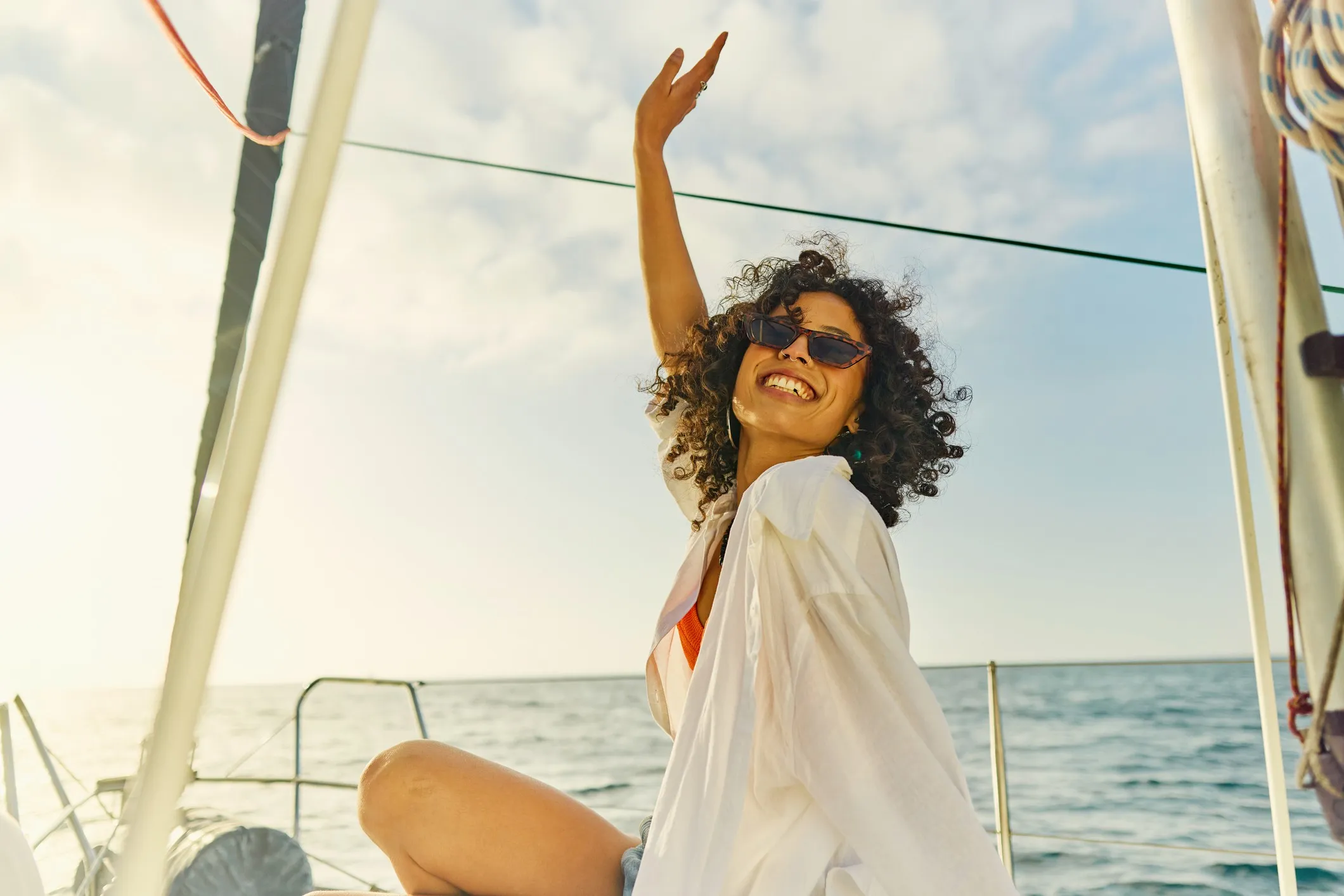 Woman enjoys getting away from it all and sailing out on the open ocean towards the setting sun